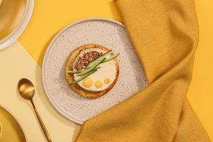 Au centre de l'image : une assiette dans laquelle on peut voir une brioche muffin La Boulangère avec 60 g de cream cheese 2 cuillères à soupe de crème de citron 1 poignée de granola émietté Quelques filaments de concombre
